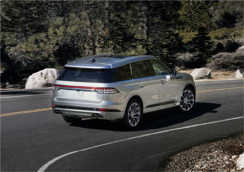 A 2023 Lincoln Aviator® Grand Touring model is shown being driven on a tight turn of a mountain road | Sedano Lincoln in La Mesa CA