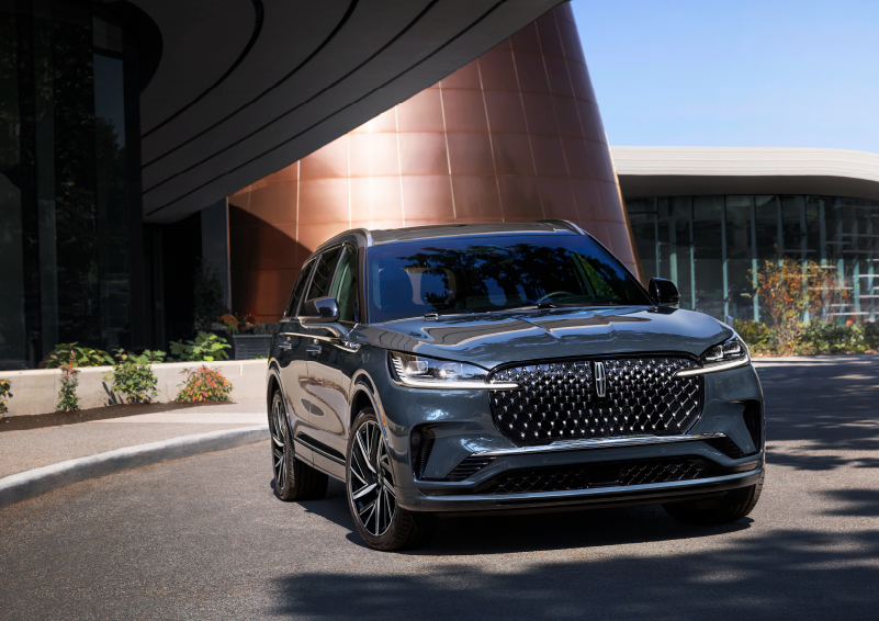 A gray 2025 Lincoln Aviator® SUV is parked outside a modern building with the sun shining. | Sedano Lincoln in La Mesa CA