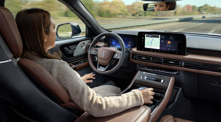 A woman is seen sitting in the driver’s seat of her 2025 Lincoln Aviator® SUV with her hands off the steering wheel. | Sedano Lincoln in La Mesa CA