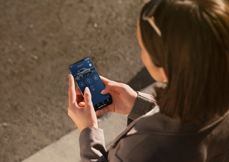 A person is shown interacting with a smartphone to connect to a Lincoln vehicle via the Lincoln Way® App. | Sedano Lincoln in La Mesa CA