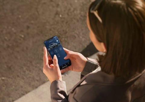 A person is shown interacting with a smartphone to connect to a Lincoln vehicle via the Lincoln Way® App. | Sedano Lincoln in La Mesa CA