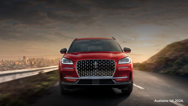A 2025 red Lincoln Corsair® SUV is being driven down a road at sunset. | Sedano Lincoln in La Mesa CA