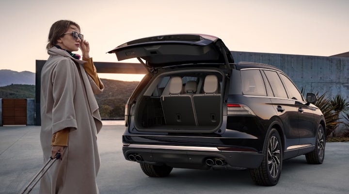 A woman approaches a 2026 Lincoln Aviator® SUV with its rear liftgate open. | Sedano Lincoln in La Mesa CA