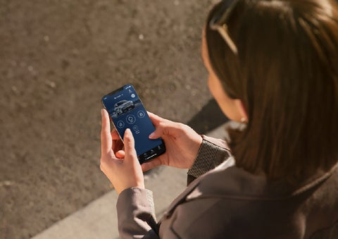A person is shown interacting with a smartphone to connect to a Lincoln vehicle via the Lincoln Way® app. | Sedano Lincoln in La Mesa CA